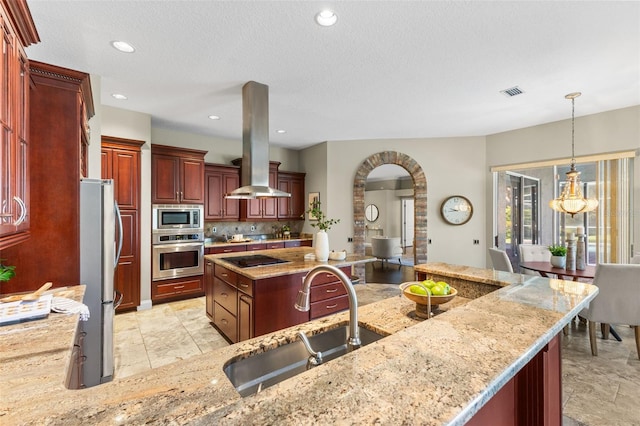 4690 Wrentham Pl, Palm Harbor, FL 34685 - kitchen with stainless steel appliances, island exhaust hood, reddish brown cabinets, arched walkways, and light stone counters