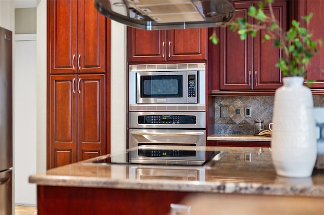 4690 Wrentham Pl, Palm Harbor, FL 34685 - kitchen with stainless steel appliances, range hood, reddish brown cabinets, and backsplash