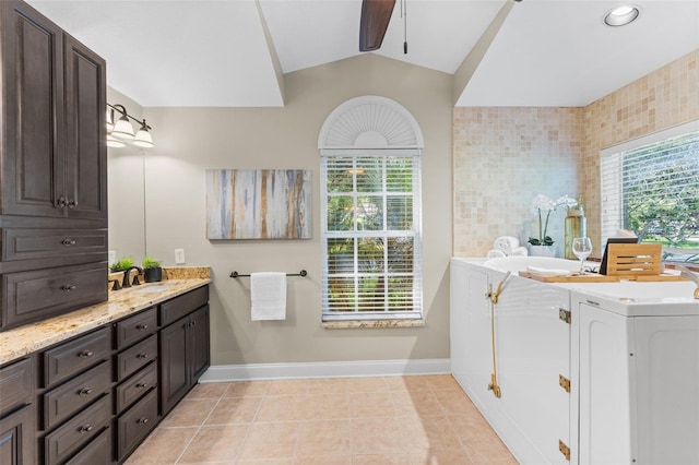 4690 Wrentham Pl, Palm Harbor, FL 34685 - bathroom featuring washing machine and dryer, vanity, ceiling fan, lofted ceiling, and tile patterned floors