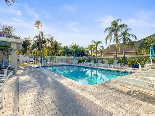 community pool with fence and a patio area
