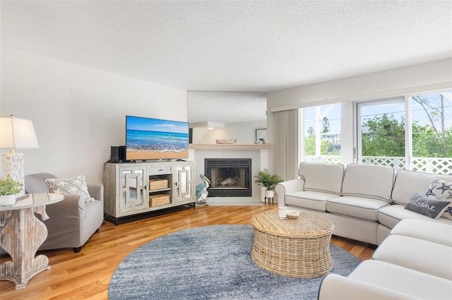 623 Garland Cir, Indian Rocks Beach, FL 33785 - living area with plenty of natural light, a tile fireplace, a textured ceiling, and wood finished floors