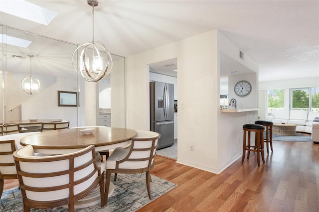 623 Garland Cir, Indian Rocks Beach, FL 33785 - dining area with a skylight, light wood-type flooring, and a chandelier