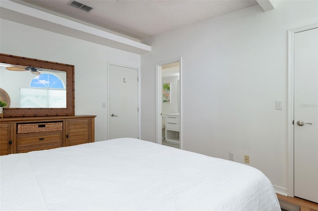 623 Garland Cir, Indian Rocks Beach, FL 33785 - bedroom featuring a textured ceiling, wood finished floors, and ensuite bathroom