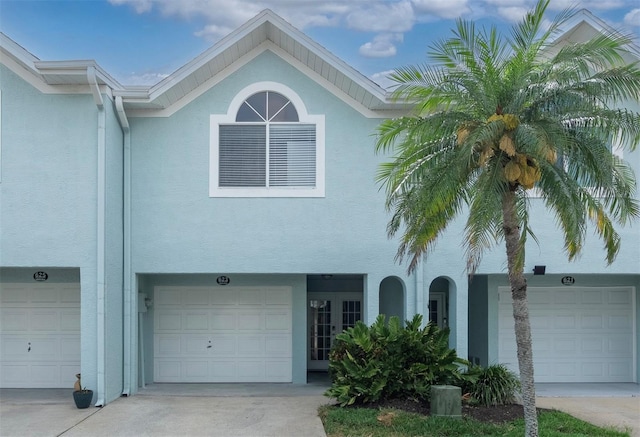 623 Garland Cir, Indian Rocks Beach, FL 33785 - view of property with stucco siding, a garage, and driveway