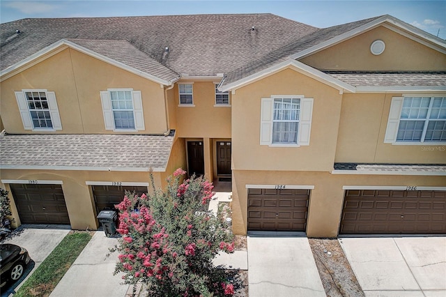 view of property with a garage and stucco siding
