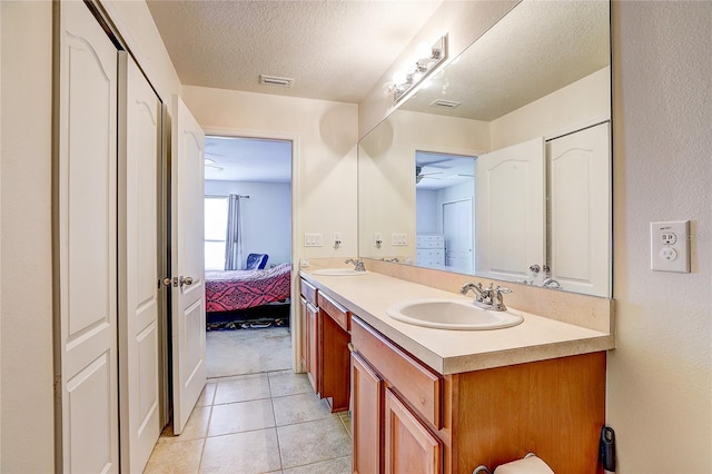 ensuite bathroom with connected bathroom, double vanity, visible vents, and a sink