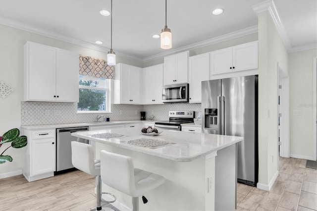 11626 Blue Woods Dr, Riverview, FL 33569 - kitchen featuring stainless steel appliances, white cabinetry, a kitchen island, ornamental molding, and recessed lighting