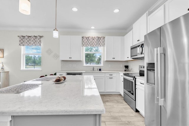 11626 Blue Woods Dr, Riverview, FL 33569 - kitchen featuring stainless steel appliances, a sink, a center island, white cabinetry, and crown molding