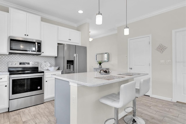 11626 Blue Woods Dr, Riverview, FL 33569 - kitchen featuring stainless steel appliances, crown molding, light wood finished floors, a center island, and white cabinetry