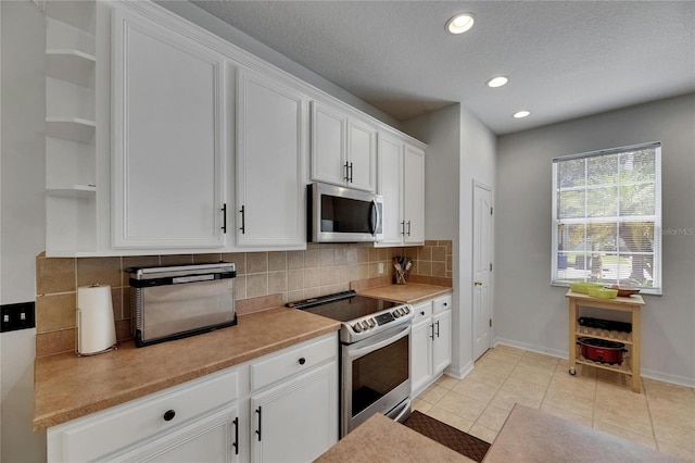 10636 Dawns Light Dr, Riverview, FL 33578 - kitchen featuring stainless steel appliances, open shelves, decorative backsplash, white cabinetry, and light countertops