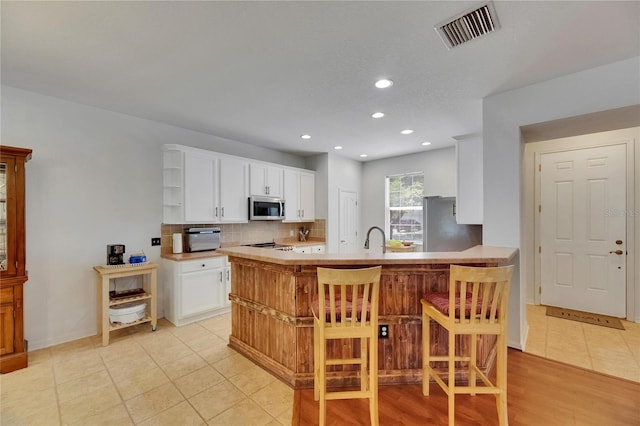 10636 Dawns Light Dr, Riverview, FL 33578 - kitchen with stainless steel appliances, open shelves, recessed lighting, backsplash, and white cabinets