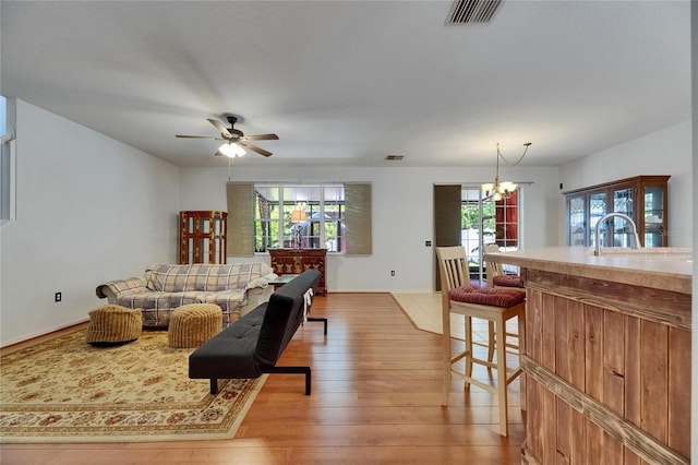 10636 Dawns Light Dr, Riverview, FL 33578 - living area with light wood-style floors, a ceiling fan, and a chandelier