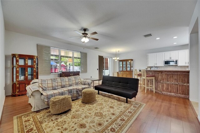 10636 Dawns Light Dr, Riverview, FL 33578 - living room featuring plenty of natural light, a ceiling fan, light wood-style floors, a chandelier, and recessed lighting