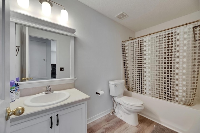 10636 Dawns Light Dr, Riverview, FL 33578 - bathroom featuring wood finished floors, toilet, vanity, shower / tub combo, and a textured ceiling
