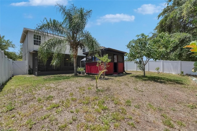 10636 Dawns Light Dr, Riverview, FL 33578 - fenced backyard featuring a storage unit, an outdoor structure, a gate, and a sunroom