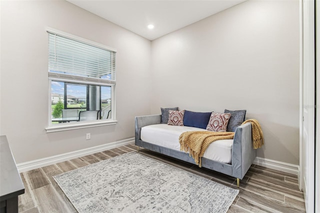 sitting room with baseboards, wood finished floors, and recessed lighting