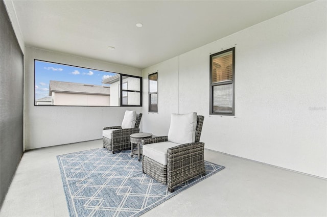 sitting room with healthy amount of natural light and concrete floors