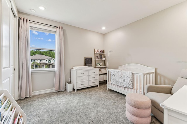 carpeted bedroom with a crib, recessed lighting, and baseboards