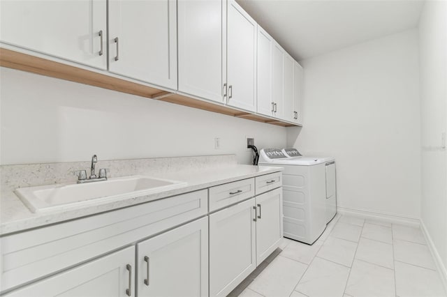 laundry area with cabinet space, washing machine and dryer, baseboards, and light tile patterned floors