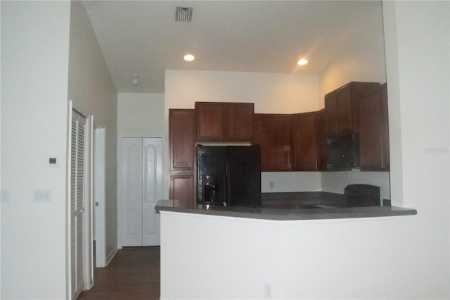 kitchen with visible vents, dark countertops, fridge, a peninsula, and recessed lighting