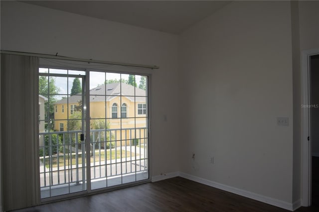unfurnished room with baseboards and dark wood-style floors