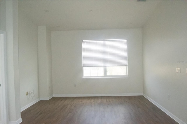 empty room featuring baseboards and wood finished floors