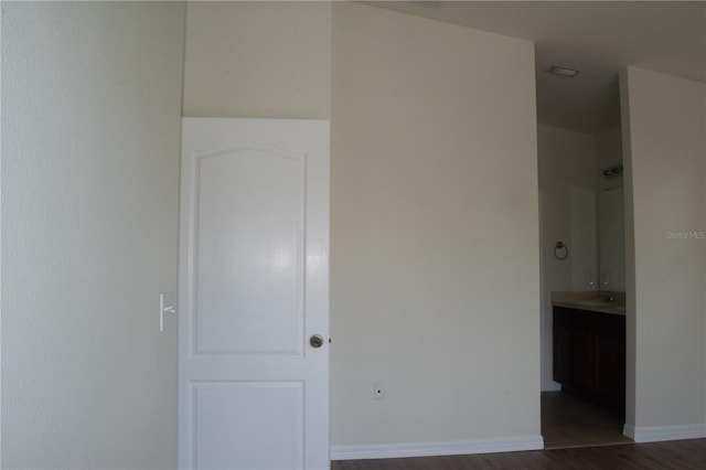 unfurnished bedroom with baseboards and dark wood-style flooring
