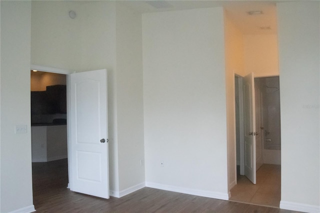 empty room with baseboards and dark wood finished floors