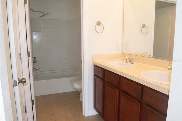 full bathroom featuring double vanity, a sink, tile patterned flooring, and toilet