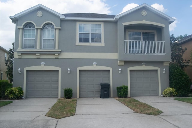 view of front facade featuring concrete driveway, stucco siding, and an attached garage