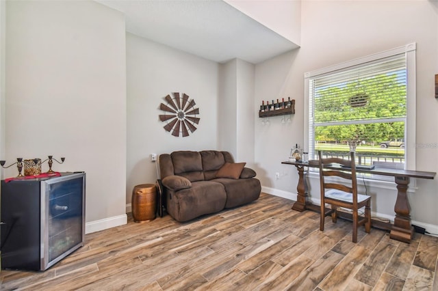 living area with baseboards and wood finished floors