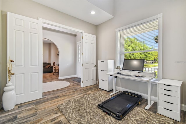 home office with baseboards, arched walkways, wood finished floors, and recessed lighting