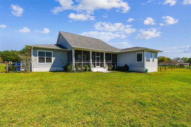 rear view of property featuring a sunroom, fence, and a yard