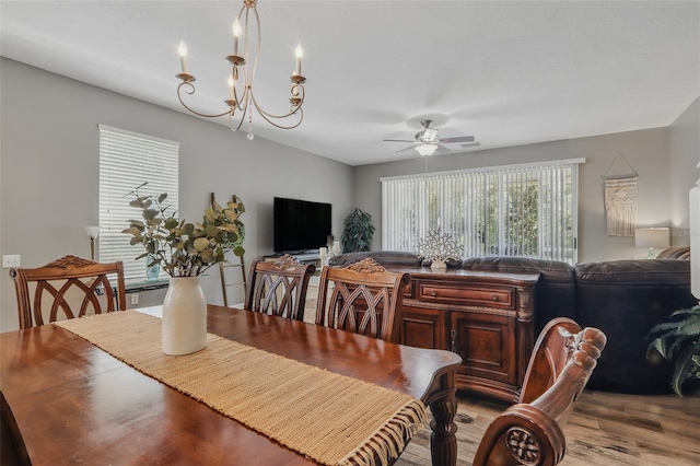 dining space featuring ceiling fan with notable chandelier and light wood finished floors