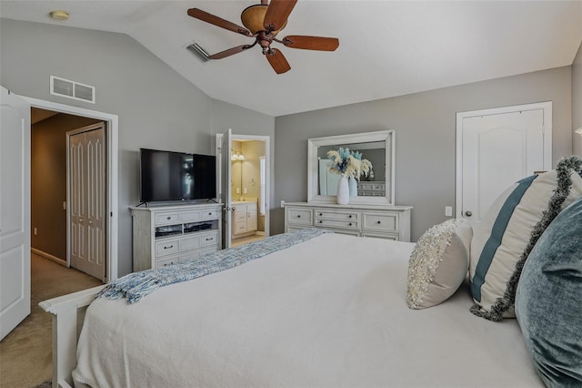carpeted bedroom featuring ceiling fan, vaulted ceiling, ensuite bath, and visible vents