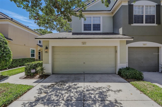 view of front of house with a garage, stucco siding, and driveway