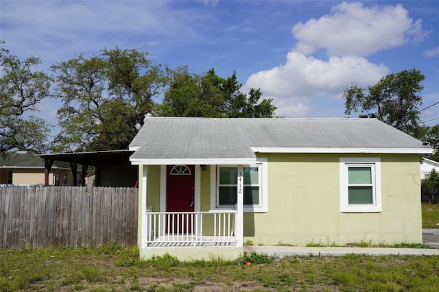 view of front of property featuring fence, covered porch, and stucco siding