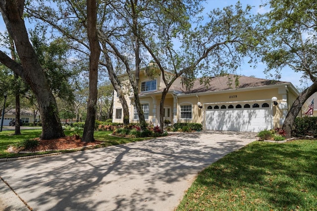 view of front of property featuring concrete driveway, stucco siding, and an attached garage