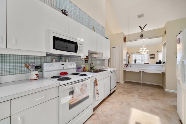 kitchen featuring white appliances, a chandelier, a sink, and light countertops
