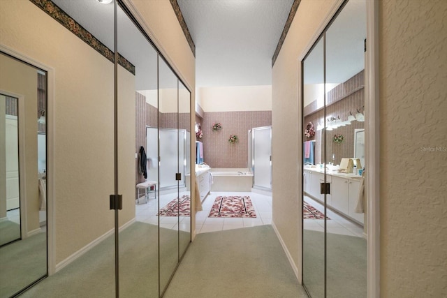 bathroom featuring a garden tub, vanity, a textured wall, tile patterned floors, and a stall shower