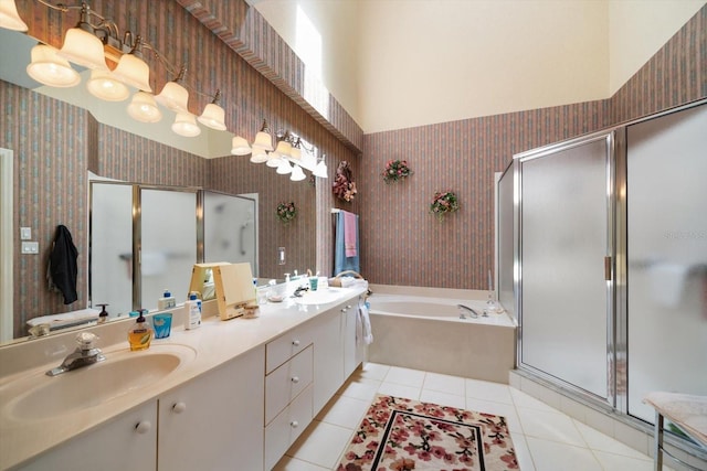 full bath with a sink, tile patterned flooring, double vanity, a shower stall, and a bath