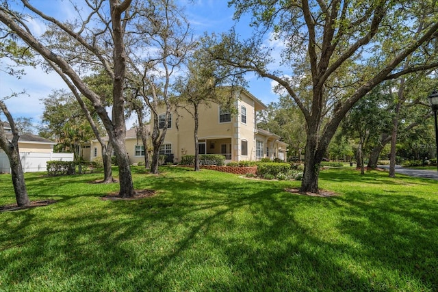 exterior space with fence, stucco siding, and a front yard