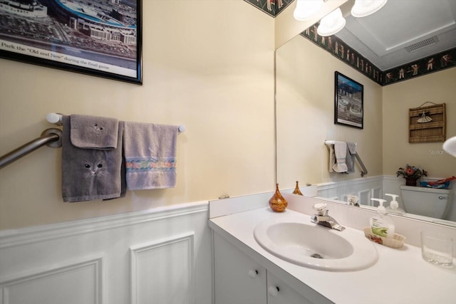 bathroom with visible vents, toilet, and vanity
