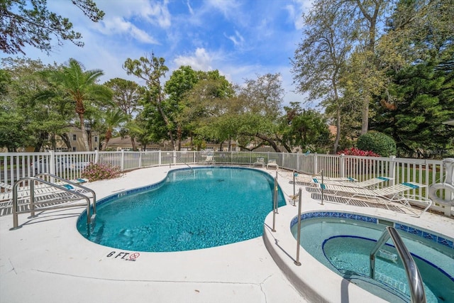 pool featuring fence, a community hot tub, and a patio area