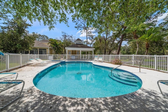 community pool featuring a gazebo, fence, and a patio area