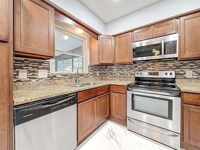 kitchen featuring marble finish floor, light stone countertops, appliances with stainless steel finishes, and a sink