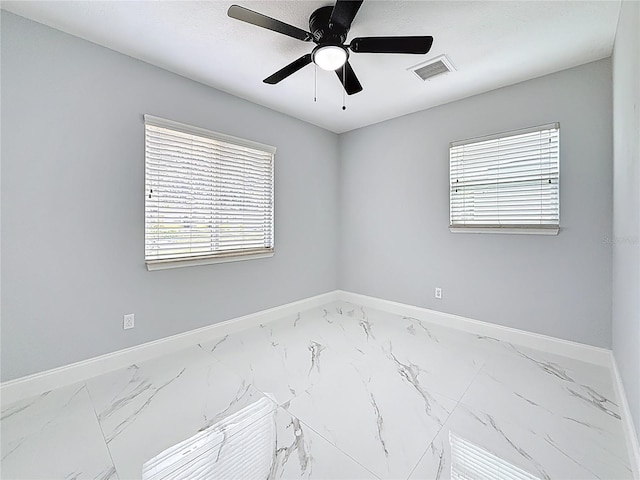 spare room featuring marble finish floor, visible vents, and baseboards