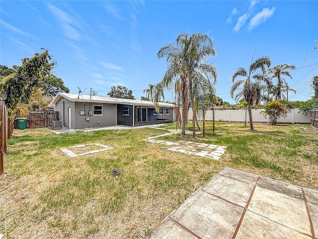 view of yard featuring a patio, a sunroom, and a fenced backyard