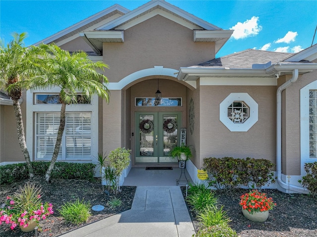 view of exterior entry with stucco siding and french doors