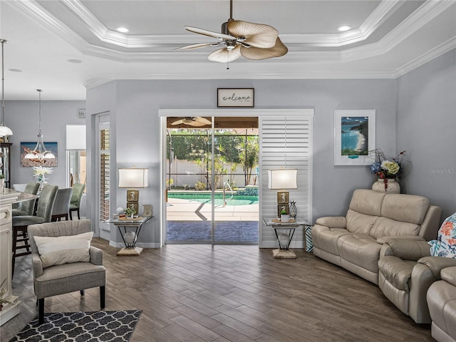 2908 89th Ave E, Parrish, FL 34219 - living room featuring a tray ceiling, ceiling fan, ornamental molding, dark wood-type flooring, and baseboards